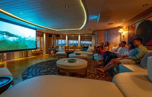 Charter yacht SUNRAYS cinema room with charter guests on seats