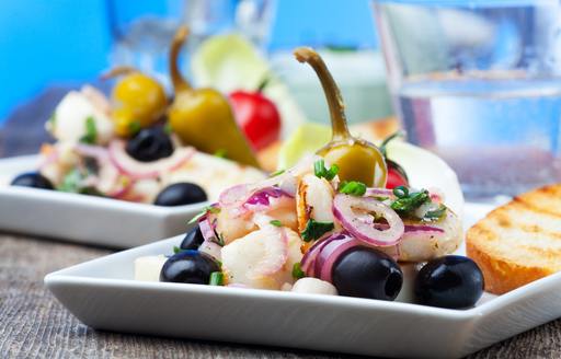 Mediterranean salad on white plates with olives