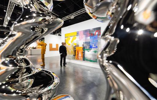 Art Basel Miami exhibit with silver sculptures in the foreground