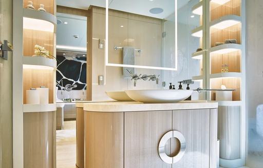 luxury yacht soaring en suite bathroom with backlit shelves and mirror showing guest cabin in background