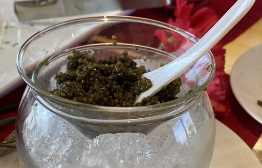 black caviar served over glass bowl of ice cubes