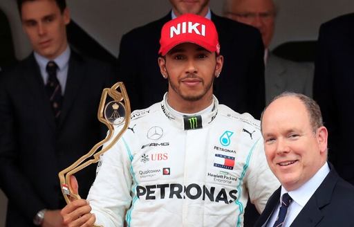 Lewis Hamilton winning the Monaco Grand Prix in the South of France, accepting his trophy and wearing red cap with 'Niki' written on it