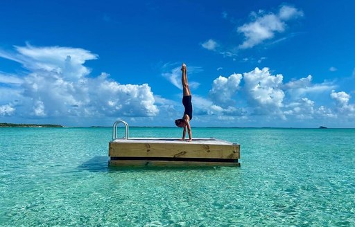 Woman doing a handstand on a pontoon in the Cay 