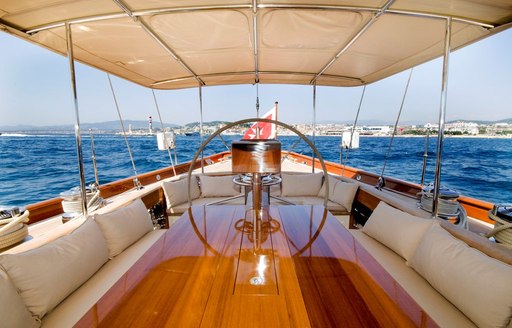 table and sofas in shaded cockpit of luxury yacht ANNAGINE 