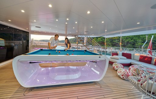 Two charter guests using a games table onboard charter yacht HAPPY ME