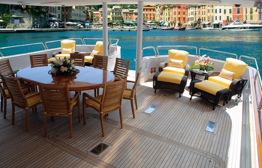 luxury motor yacht LADY J al fresco dining table and sun lounger on the teak deck