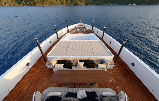 Overview of the bow onboard charter yacht AQUARIUS, alfresco dining and lounge areas with surrounding views of the sea