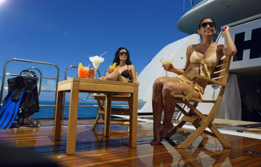 Woman enjoying drinks on beach club of superyacht HARLE in the Caribbean