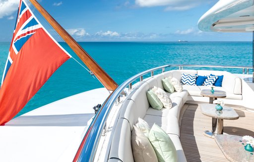 Exterior seating and a flag onboard superyacht charter TITANIA