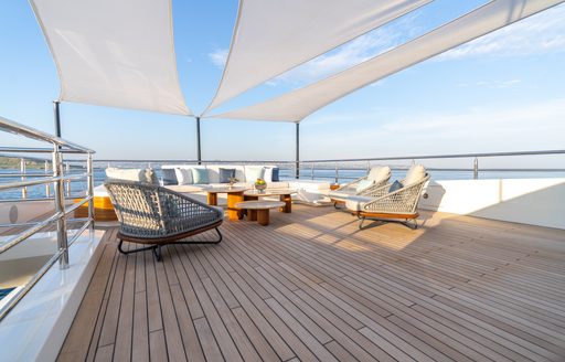 Exterior deck space onboard charter yacht ETERNAL SPARK with sunloungers and cream seating