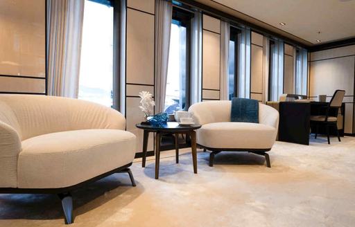 Pair of armchairs adjacent to slim windows in the master cabin onboard charter yacht RELIANCE