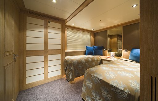 Twin guest cabin onboard yacht charter CYAN with two single berthed and a large mirror