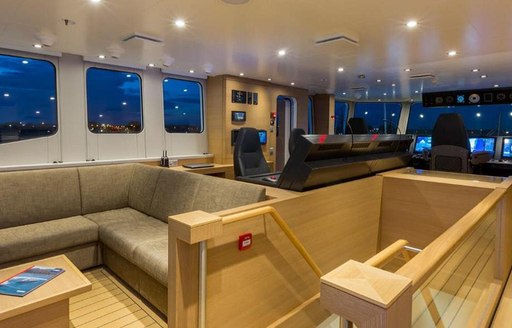 Wooden decked interior of Game Changer yacht and staircase and sofas