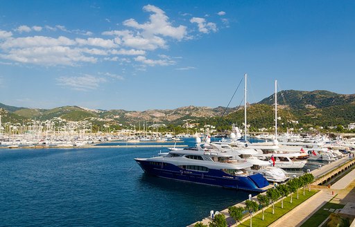 Yachts berthed in a marina beneath blue skies