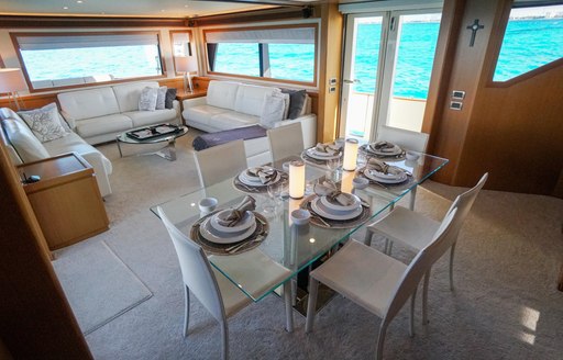 Interior of charter yacht NOMADA, with dining table and sofas visible