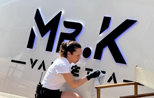 Superyacht crew member cleaning Mr K nameplate