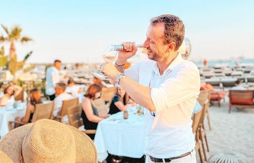 Waiter pouring wine at Plage Mademoiselle Gray