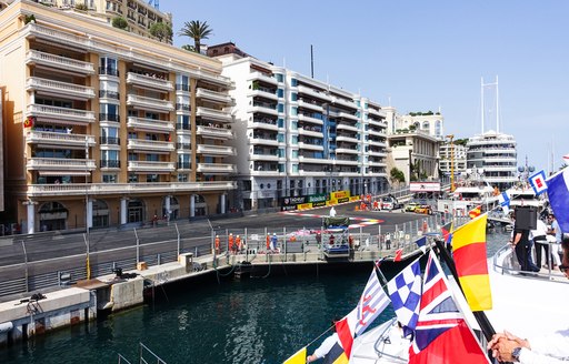 Dockside view of Monaco Grand prix track, line of Row of superyachts moored at Monaco Grand Prix