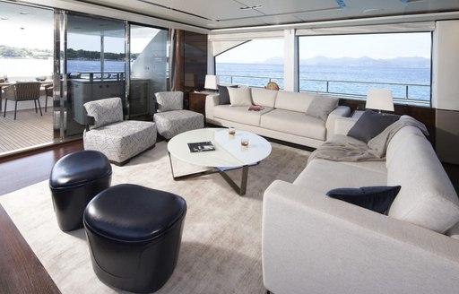 Main salon lounge onboard charter yacht ANKA, plush cream seating with large windows aft