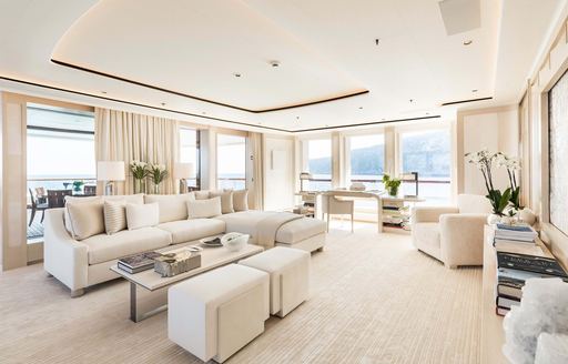 Cream color interior lounge with plush seating and large windows onboard superyacht charter SOPHIA