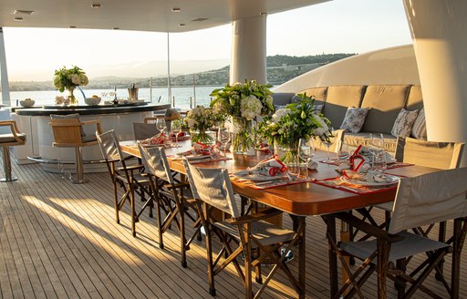 sundeck on luxury yacht spirit, with large dining table and bar with barstools