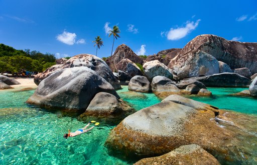 Snorkelling in bright blue sea between famous boulders in the Virgin Islands