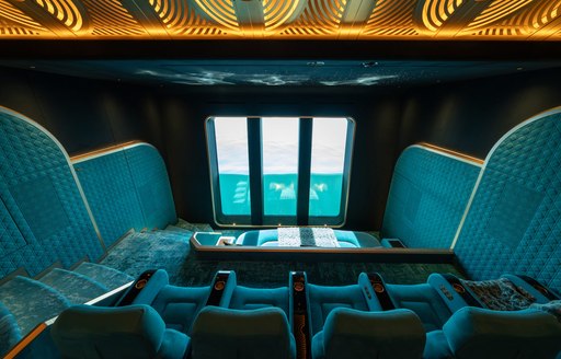 Indoor cinema with teal seating onboard charter yacht KISMET