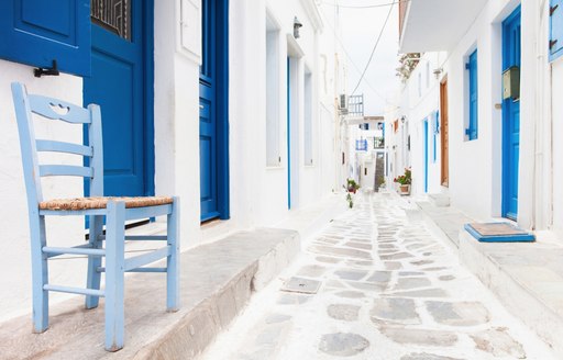 White houses and blue doors in a cobbled alleyway in Greece