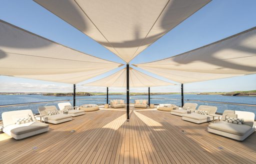 Exterior deck space onboard charter yacht KISMET, sunloungers dotted around under canopy