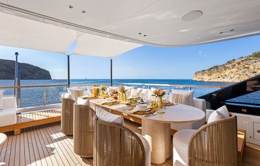 Alfresco dining setup with a long table set for a meal onboard charter yacht LIV LOVE