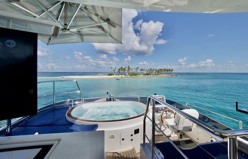 Overview of an on-deck Jacuzzi onboard charter yacht Cool Breeze, with views of a remote island in the background