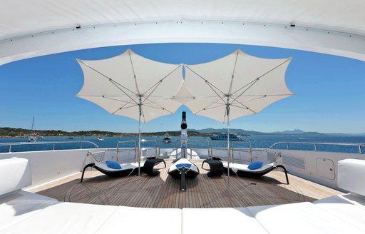 view of sun loungers from the retractable clam on board charter yacht INCEPTION