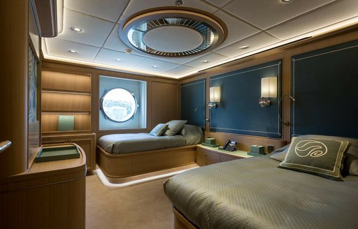 Twin cabin onboard charter yacht DREAM, with two single berths and a large porthole shaped window