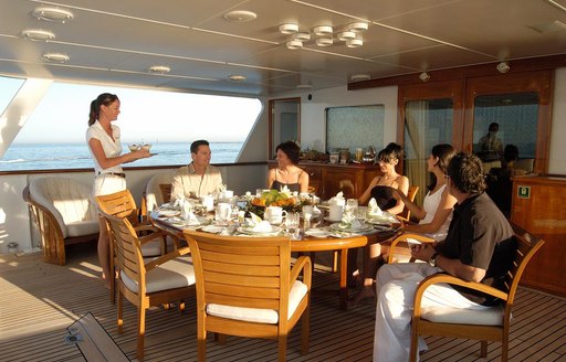 Guest at outdoor table on Top view of Illusion I yacht