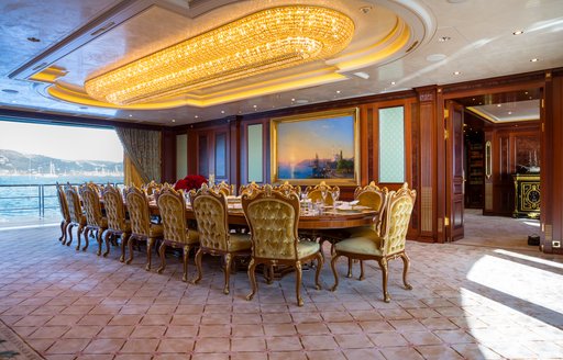 Interior dining room onboard charter yacht BLACK PEARL with long table and opulent chairs