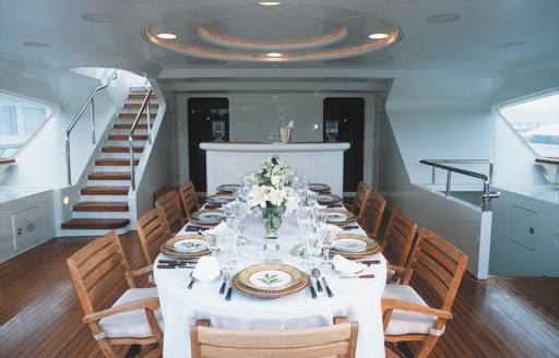 rectangular alfresco dining table on upper deck aft of luxury yacht ALEXANDRA