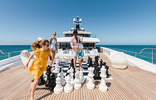 Yacht charter guests play a life-size chess game on the aft deck