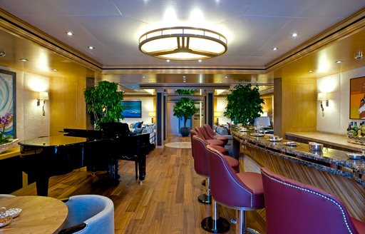 bar and grand piano in main entrance on main deck of superyacht ‘Indian Empress’ 