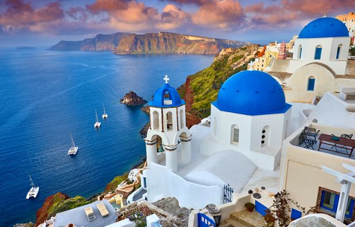 Buildings on cliff face in Santorini, Greece, overlooking the sea