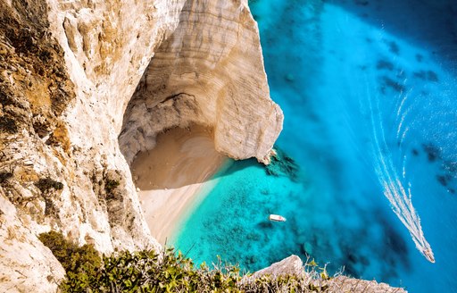 aerial view of bright blue sea and rocky beach and cove in greece