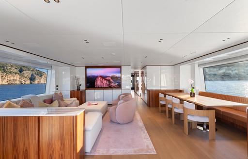 Upper salon onboard charter yacht LIV LOVE with lounge seating and dining table