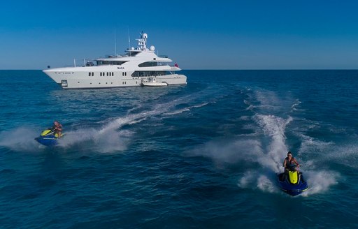 Two jet skis speeding away from Superyacht BACA