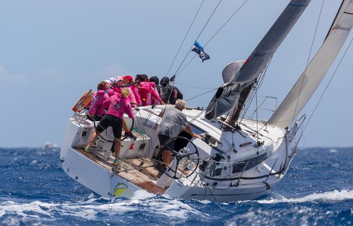 Charter yacht at Les Voiles de Saint Barth, with crew on the edge of the yacht 