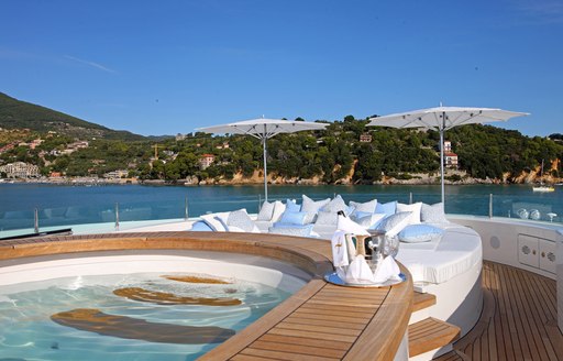 Benetti luxury yacht St David anchored in the Mediterranean with a Jacuzzi and seating area. 