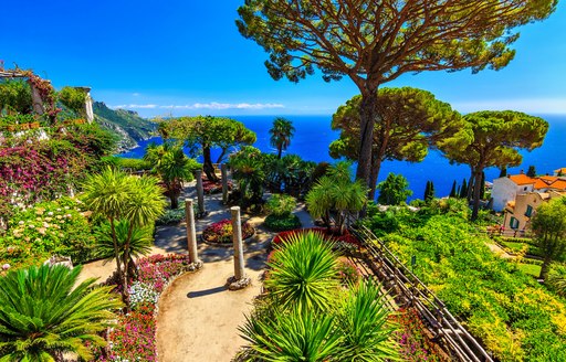 Green mountainous path looking down to clear sea