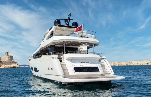 Aft view of charter yacht NEW EDGE at anchor, showing the swim platform and aft deck space.