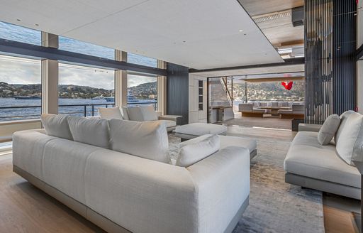 Overview of the main salon and lounge area with gray sofas onboard superyacht charter EXTRA TIME