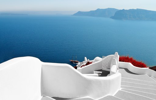 Town of Santorini in greece with white steps and red flowers