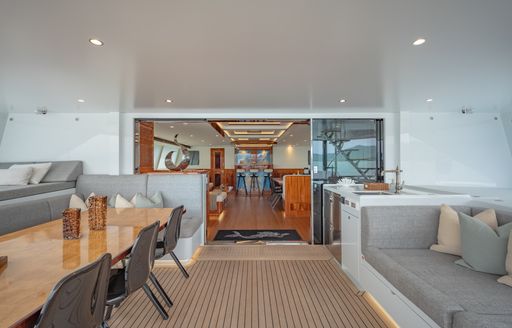 Aft deck with alfresco dining table port and lounge seating to starboard onboard sailing yacht charter CRAZY LOVE