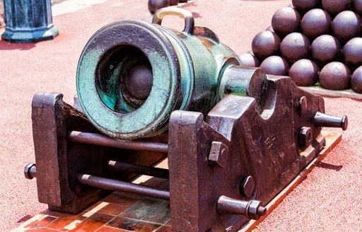 old canon and pyramid of canon balls outside princes palace in monaco 